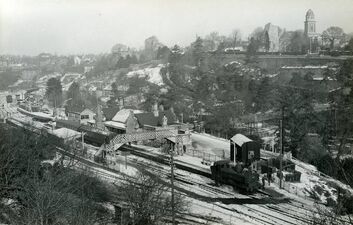 1963: Bridgnorth, View from Panpudding Hill of station and high town with snow, with GWR Pannier 3619 taking water in platform 1