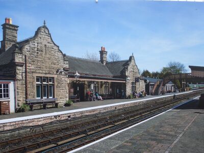Artist's impression of the new station building beyond the footbridge, with the existing building in the foreground.